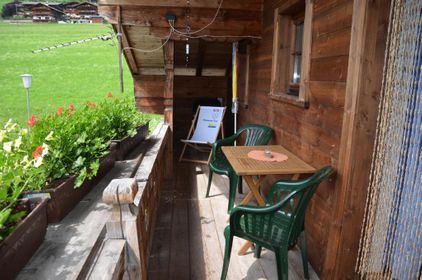 ="Balkon mit Holztisch und Geranien vom Appartement für Familienurlaub im Alpbachtal